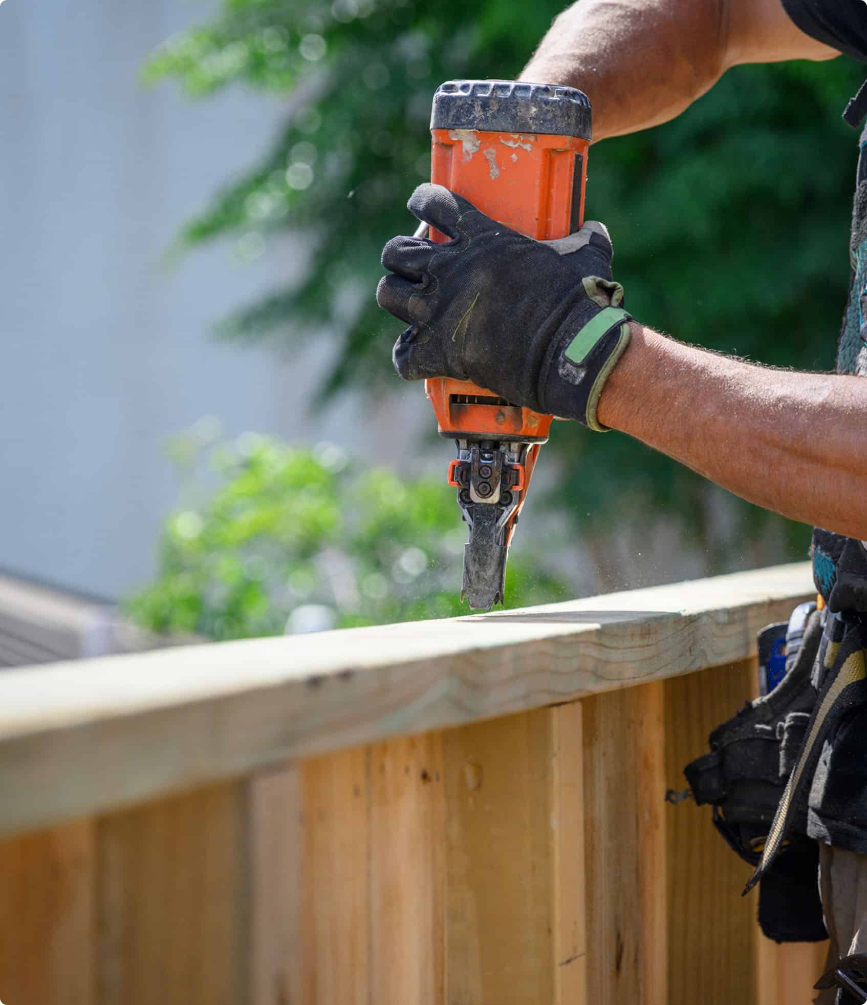 Contractor building a wooden fence with cap